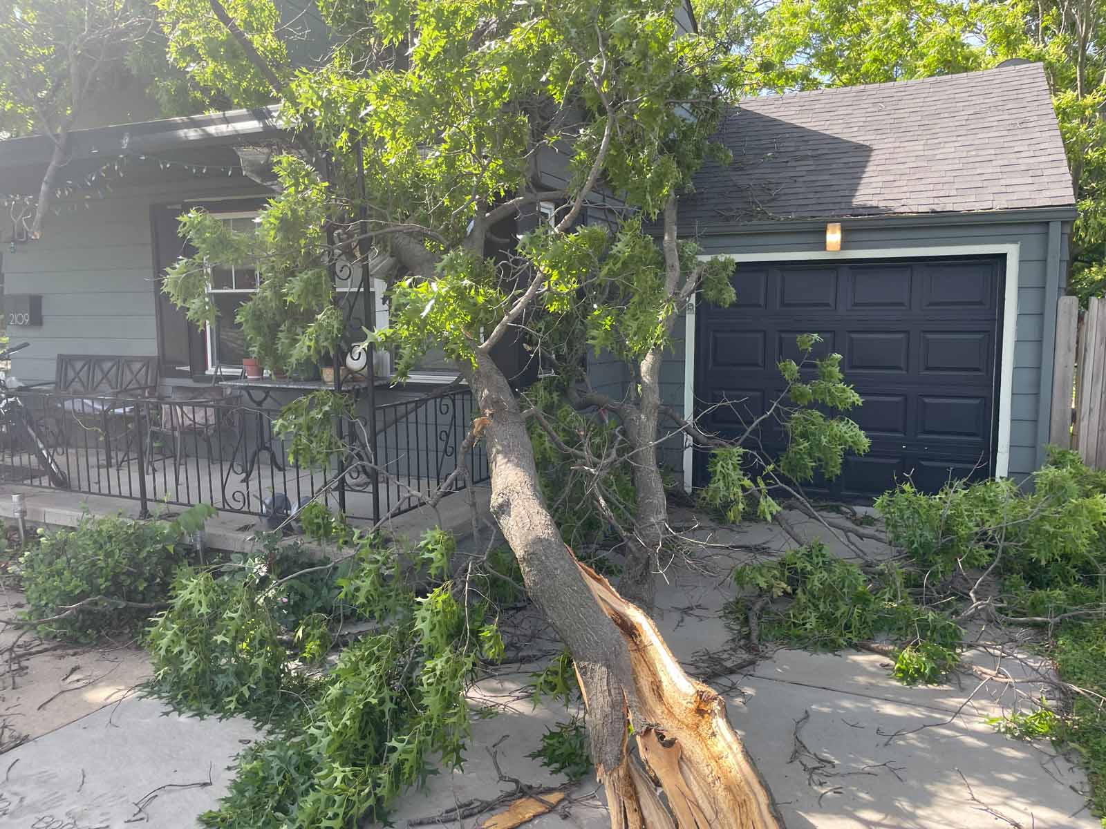 tree that has fallen on a house during a storm in Kansas